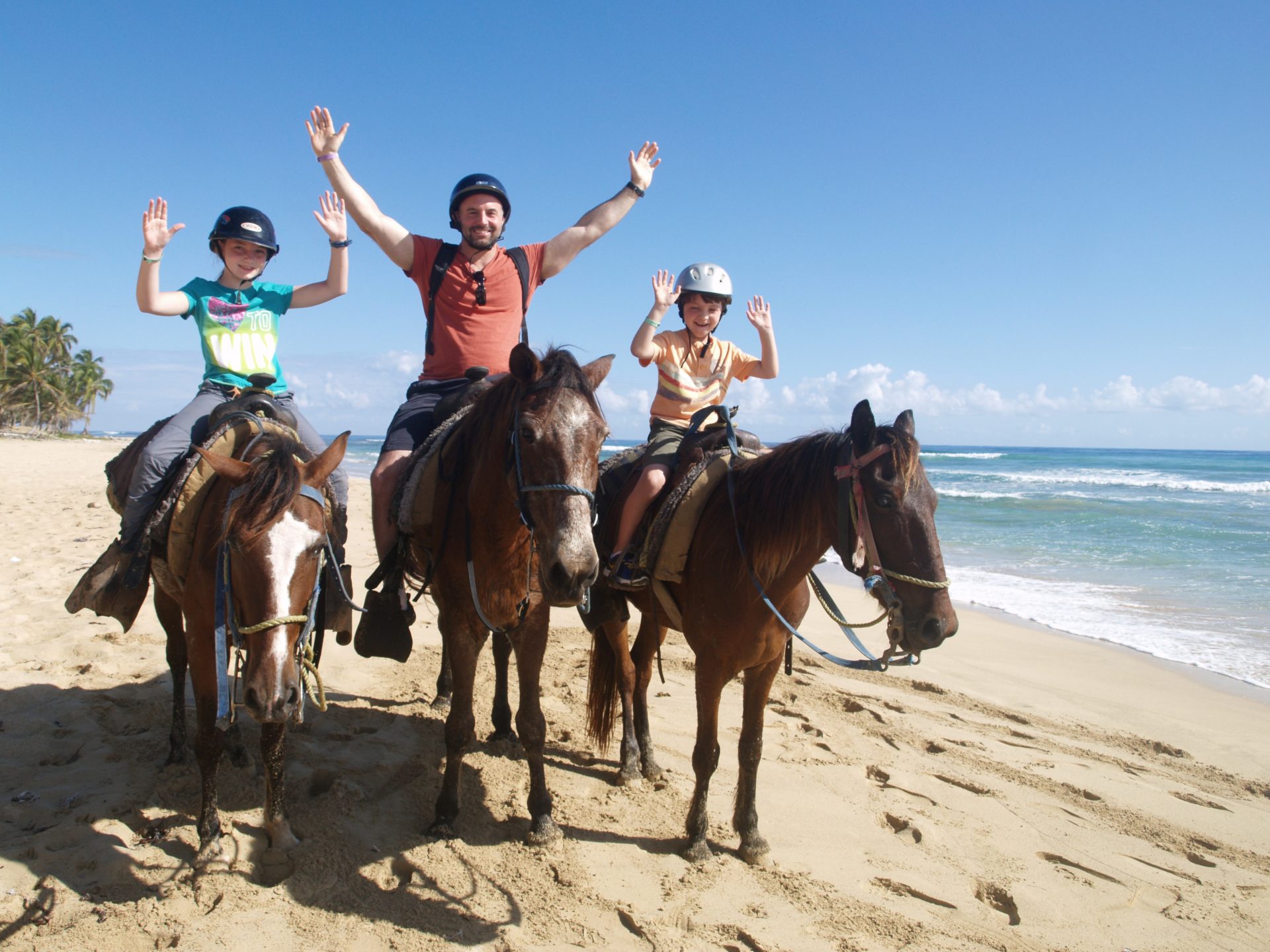 Amigos cabalgando entre el agua poco profunda en Punta Cana